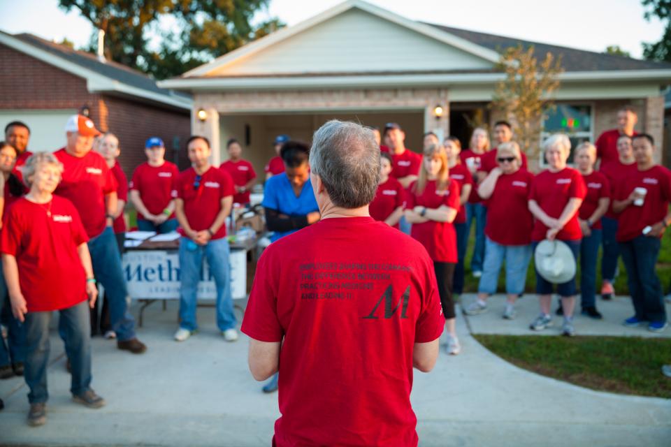 Houston Methodist President and CEO Dr. Marc Boom addresses employees taking part in a Houston Habitat for Humanity build as part of I CARE in Action.