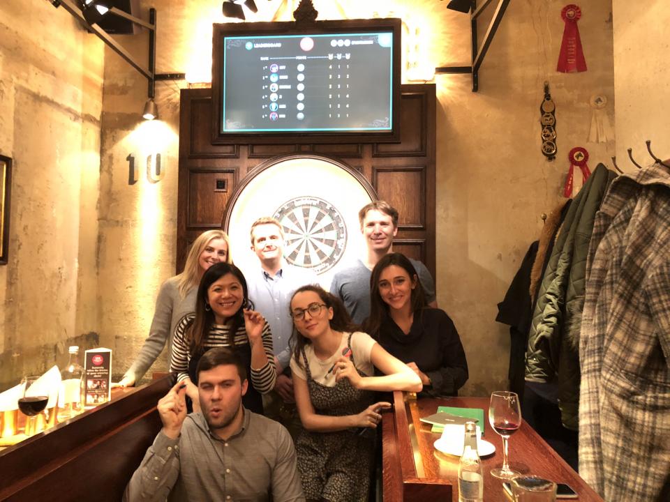 A member of the executive team travels to London every month to check in on our global offices. Here, our Director of People and VP of Product play darts with the London office on a recent trip.