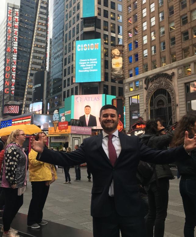 Bryant Vargas in front of our Times Square ad congratulating him on joining the firm
