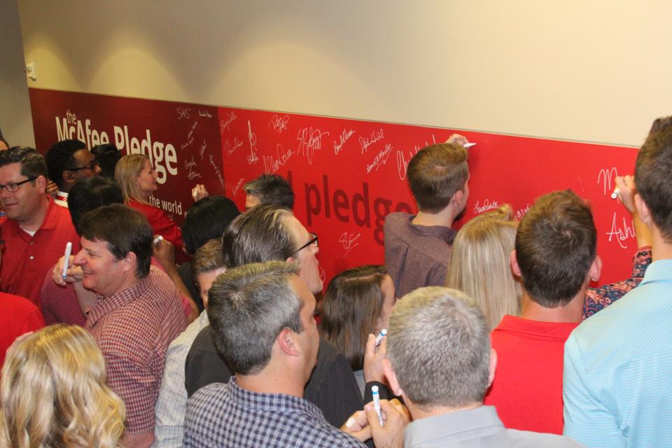 Employees signing the McAfee Pledge Wall