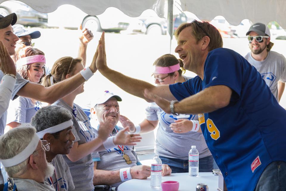 Signature HealthCARE CEO, Joe Steier, hi-fives a colleague at the annual Senior Olympics event.