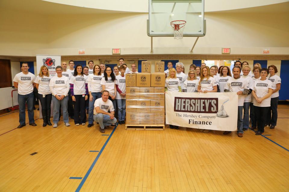 Employees posing with the meals they packed during a “Stop Hunger Now” event in Hershey, PA