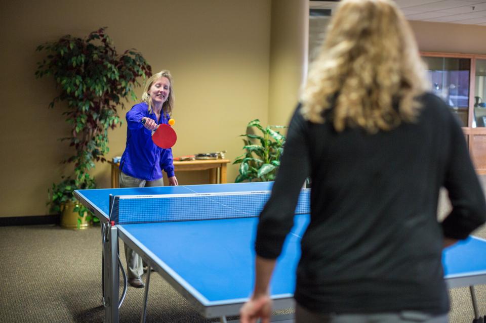 Team members playing ping pong