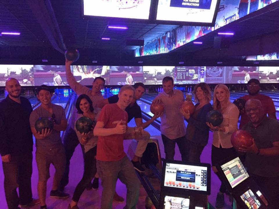 Employees enjoy bowling at a quarterly company sponsored team building event.