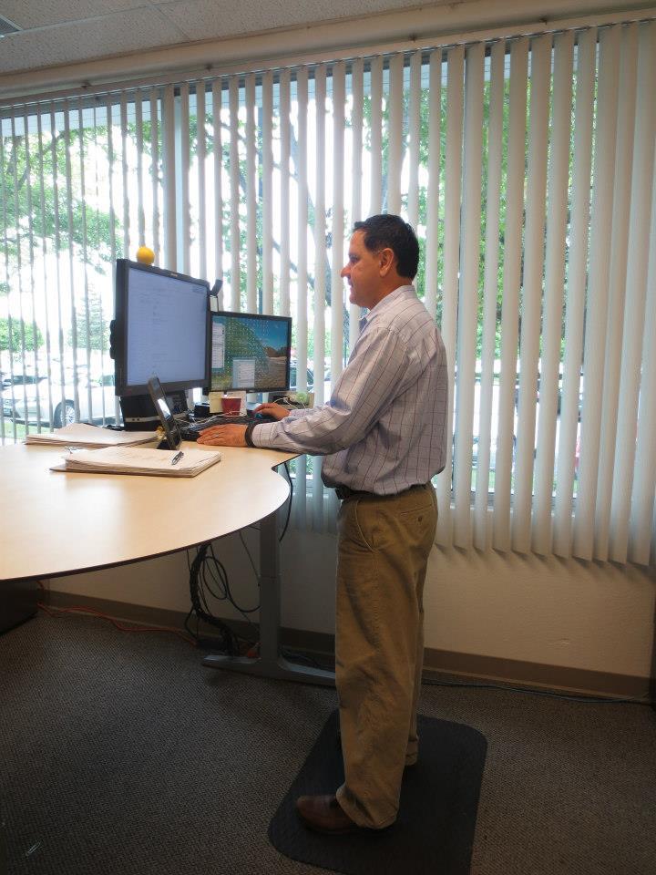 Employees enjoying the benefits of sit to stand work stations.