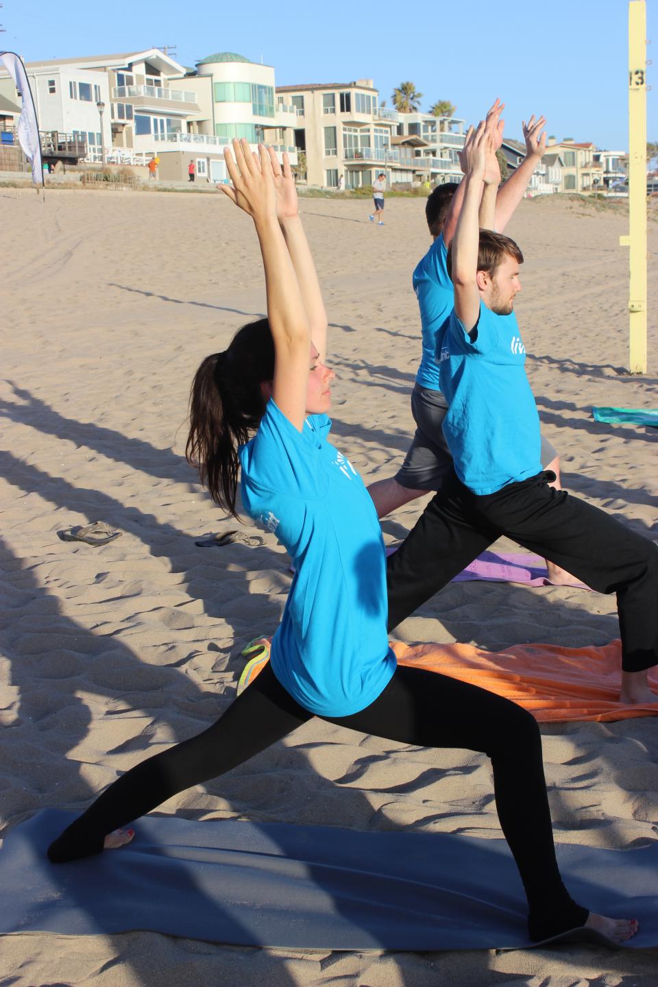 Employees participate in yoga on the beach