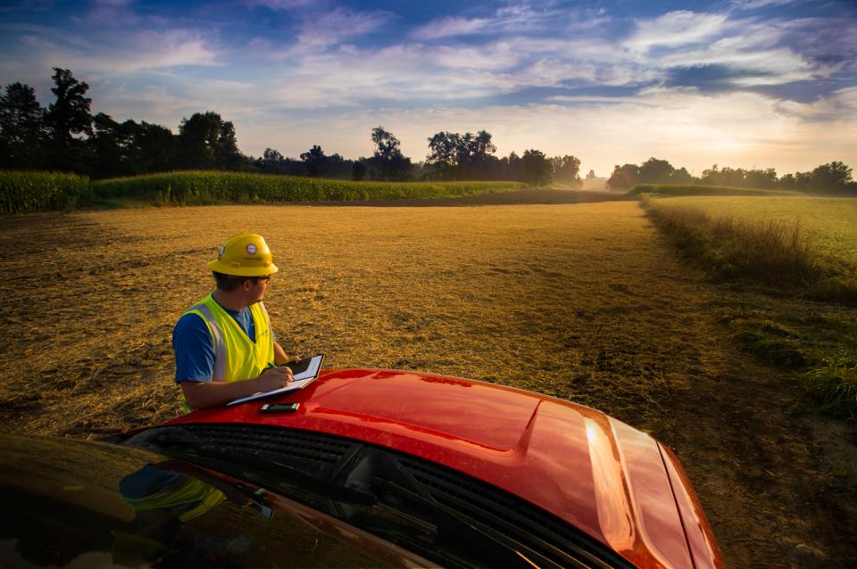 Employee Surveying a Pipeline Installation