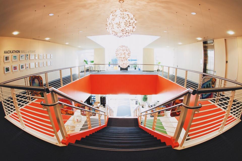 Entry staircase view from the top, with the Hackathon wall featuring previous winners