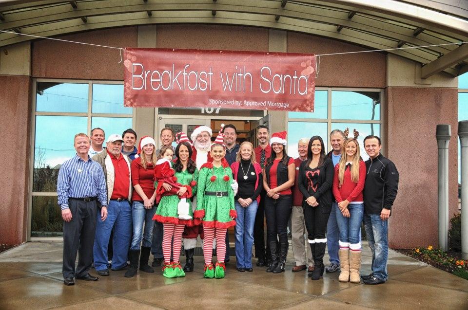 Approved Mortgage Corporation team members take a break from volunteering at the Greenwood, IN. Breakfast with Santa community event.