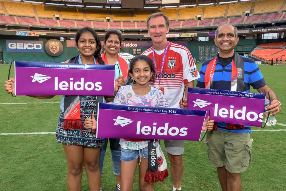 Leidos CEO Roger Krone (right) posed with Leidos employees and their families following a DC United game for employee appreciation day at RFK Stadium in Washington DC.