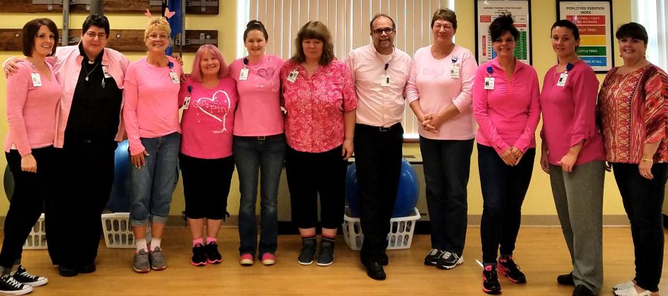 Team members proudly display shirts announcing they received their first shot of the COVID-19 vaccine.